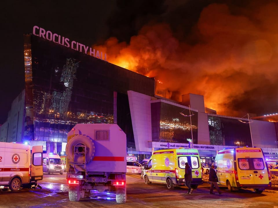 Rescue vehicles in front of a burning building.