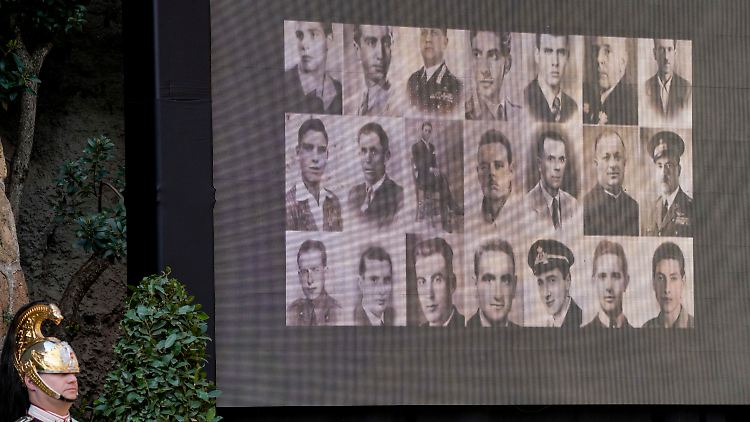 Some of the victims of the massacre can be seen on a video screen.