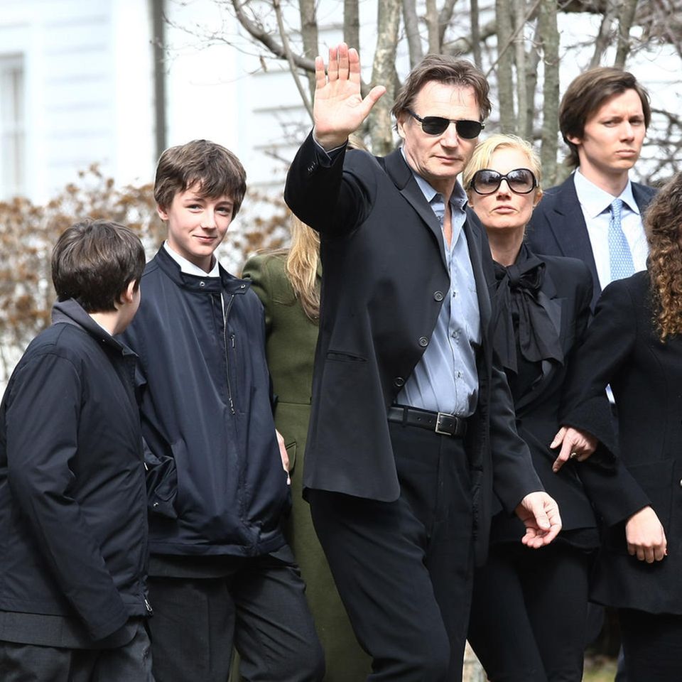 Liam Neeson (waving) with his sons Daniel (left) and Micheál Neeson (right) at Natscha Richardson's funeral at St. Peter's Lithgow Episcopal Church on March 22, 2009 in Lithgow, New York.