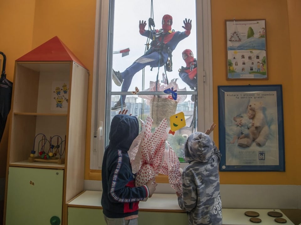 Men in Spiderman costumes distribute Easter eggs to children at a children's ward in Milan.