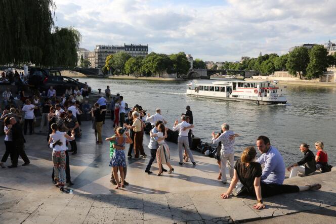 People dance on the banks of the Seine in Paris on June 24, 2017.