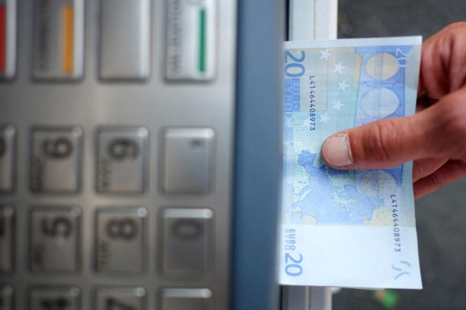 A man takes out banknotes from an ATM, in Carquefou, western France, September 10, 2014. 