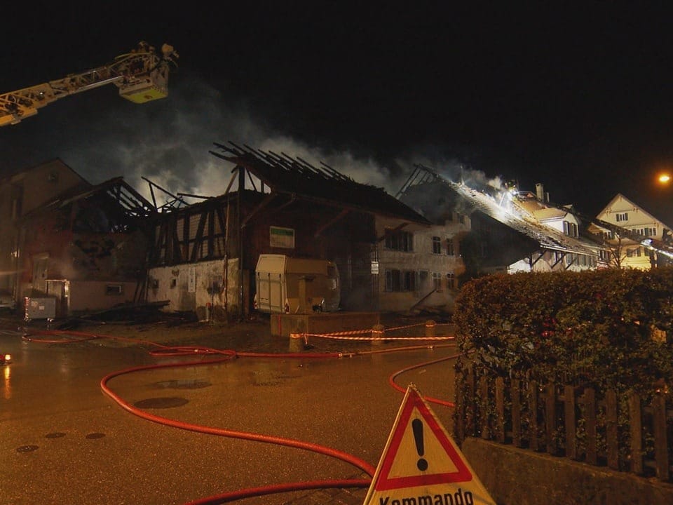 Image of one of the buildings damaged by the fire in Elgg.  In front of it there is a fire brigade crane and a Triopan on the street.