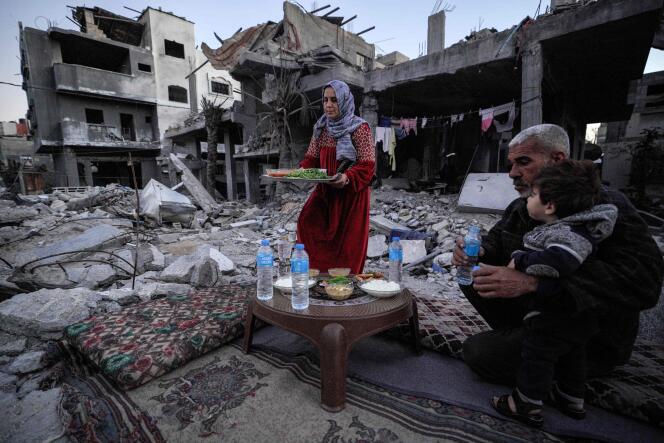 A Palestinian family breaks their fast amid ruins in Deir Al-Balah, in the central Gaza Strip, March 11, 2024.