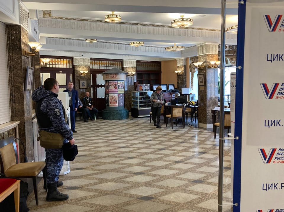View of a foyer of the polling station;  uniformed soldier visible.