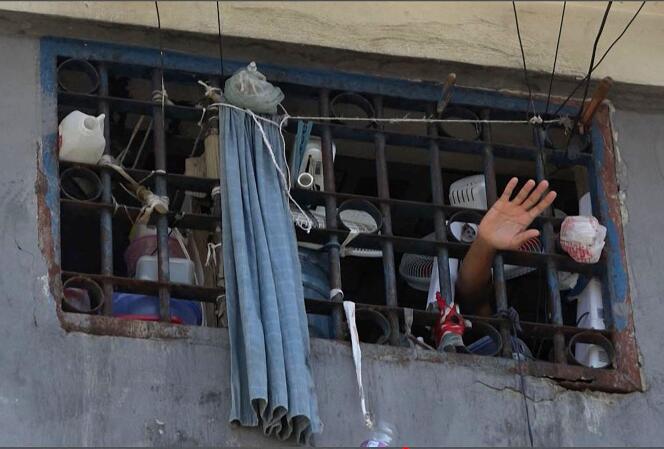 This AFP-TV screenshot shows a person waving from a cell at the main prison in Port-au-Prince on March 3, 2024, after the escape of several thousand inmates.