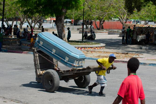 A man pulls a cart on which a coffin is placed, in a street in Port-au-Prince, March 22, 2024.