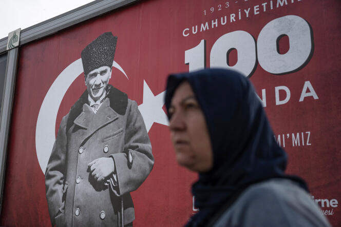 A woman walks past a banner with the portrait of Mustafa Kemal Ataturk ahead of celebrations marking the 100th anniversary of the Turkish Republic in Edirne, marking the end of the Caliphate, western Turkey, October 25, 2023.