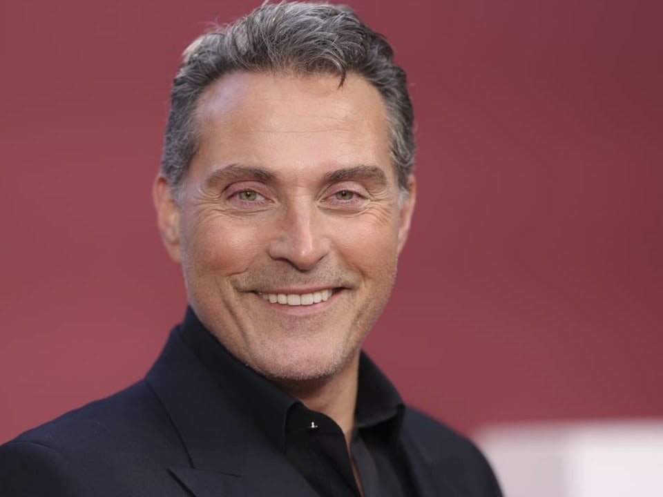 Rufus Sewell laughs into the camera