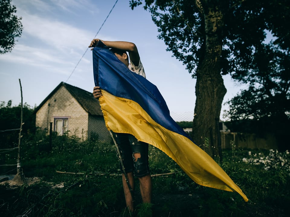 Man in countryside with Ukrainian flag
