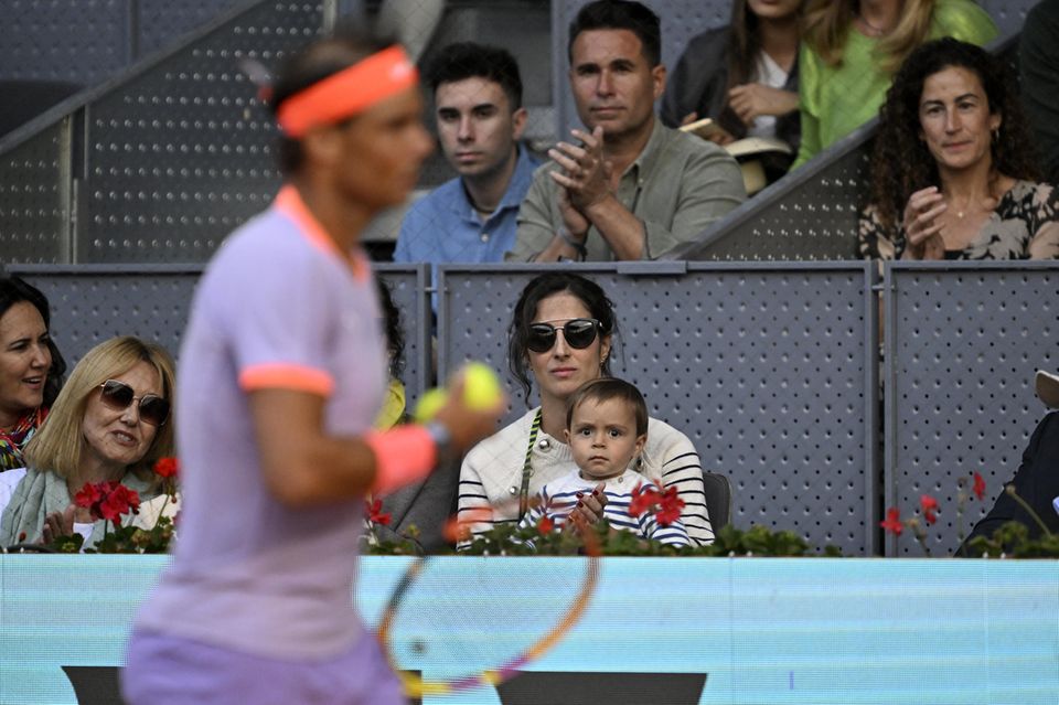 During the match, Rafael Nadal's wife Maria Francisca looks on "Xisca" Perelló with their child from the stands.