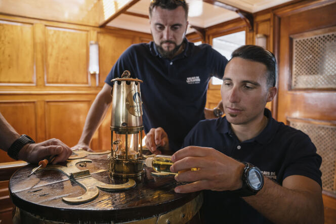 François Blaizot-Bonnemains (center) and Kévin Gendarme (right), two of the three keepers of the Olympic flame, on board the “Belem”, April 28, 2024.