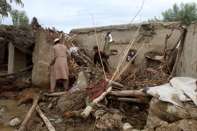 People remove debris from a flood-damaged house in Guldag village, Nangarhar province, Afghanistan, April 15, 2024.