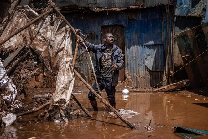 A man removes materials from a flooded area after torrential rains in Nairobi's Mathare neighborhood on April 25, 2024.