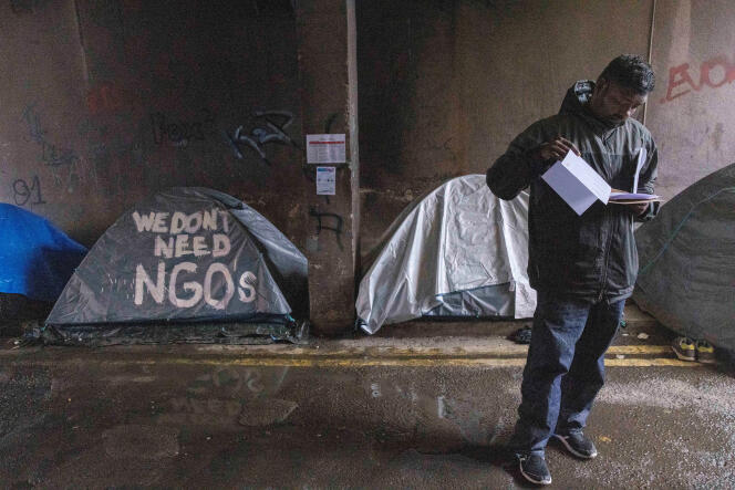 An asylum seeker examines his documents after an International Protection Office (IPO) appointment, around which hundreds of migrants have been sleeping rough in tents for several months, in Dublin, April 30, 2024.