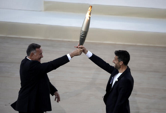 Hellenic Olympic Committee President Spyros Capralos and Tony Estanguet, President of the 2024 Olympic Organizing Committee, hold the Olympic flame on April 26, 2024 at the Panathenaic Stadium in Athens, Greece.